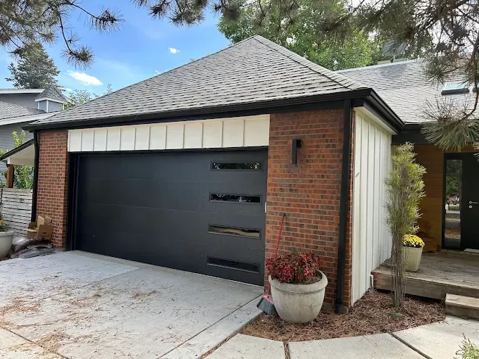 Modern brick house exterior with black garage door and light-colored trim