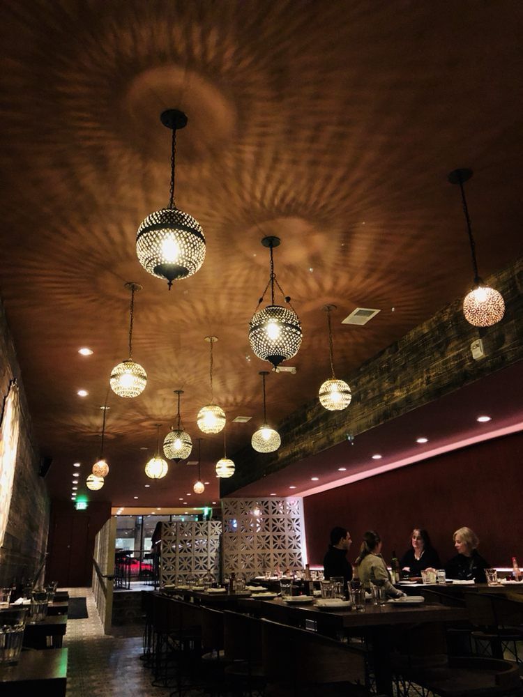 A restaurant with a lot of lights hanging from the ceiling