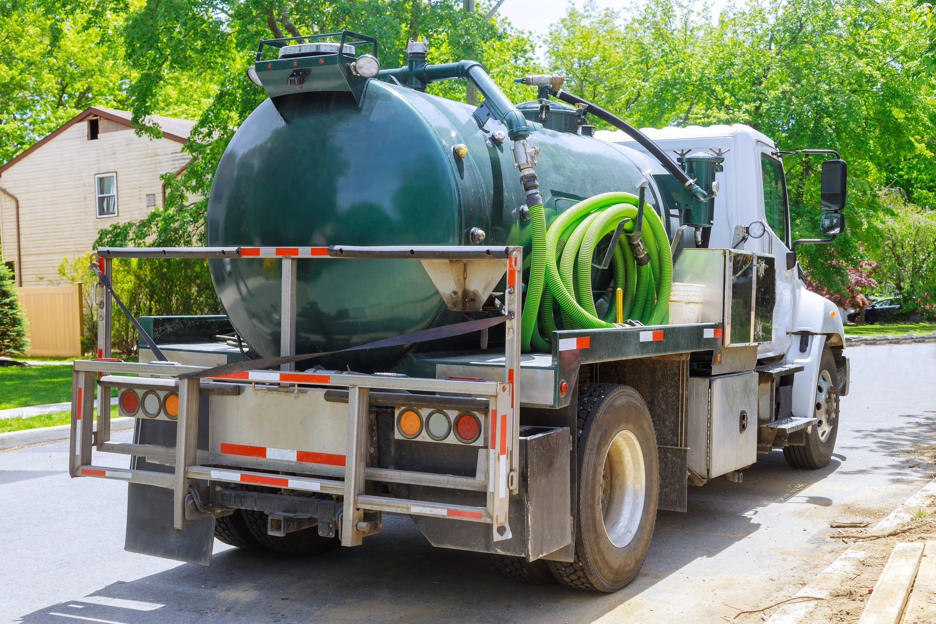 Un camion aspirateur est stationné sur le bord de la route.