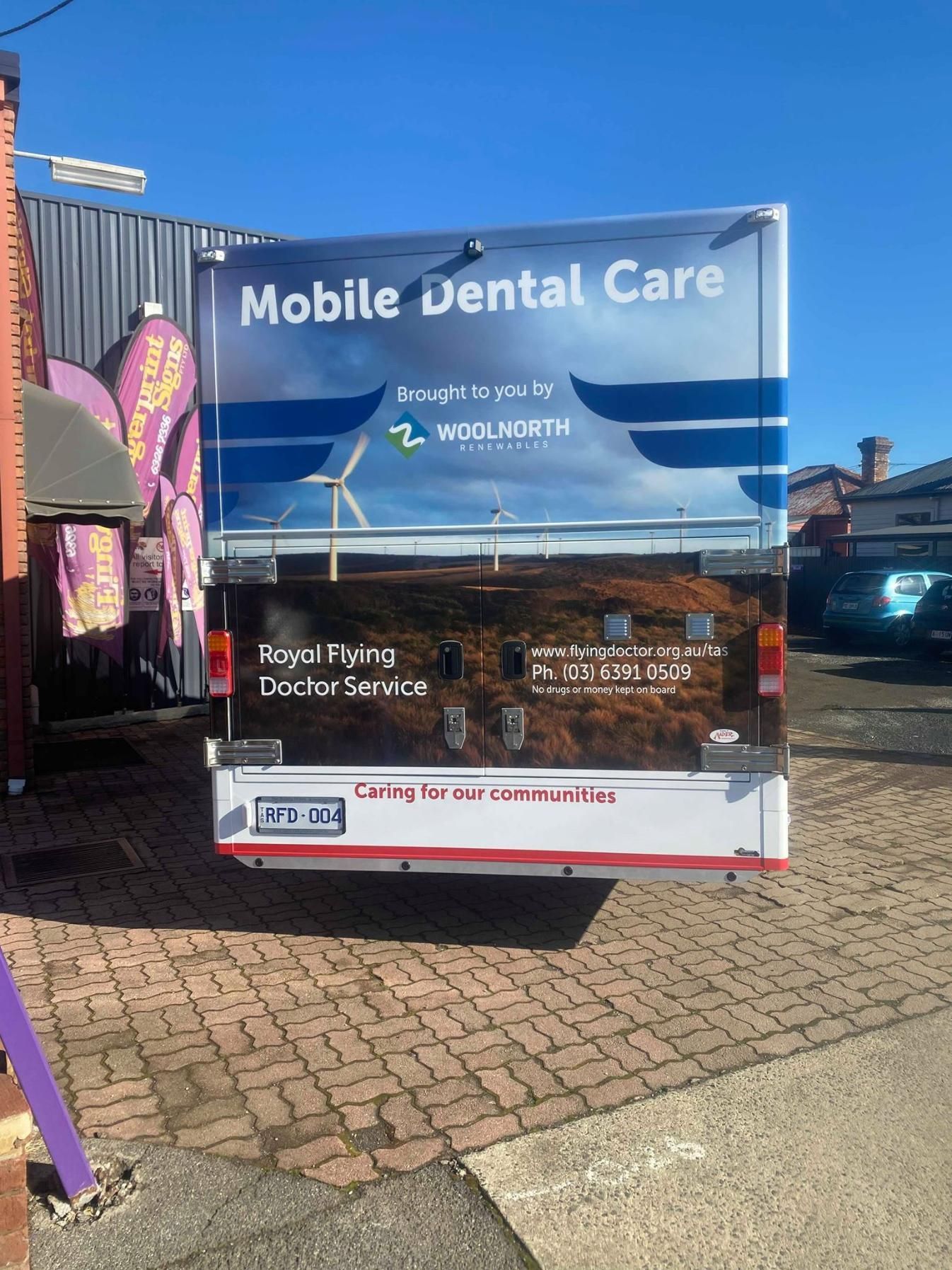 A mobile dental care van is parked in a parking lot