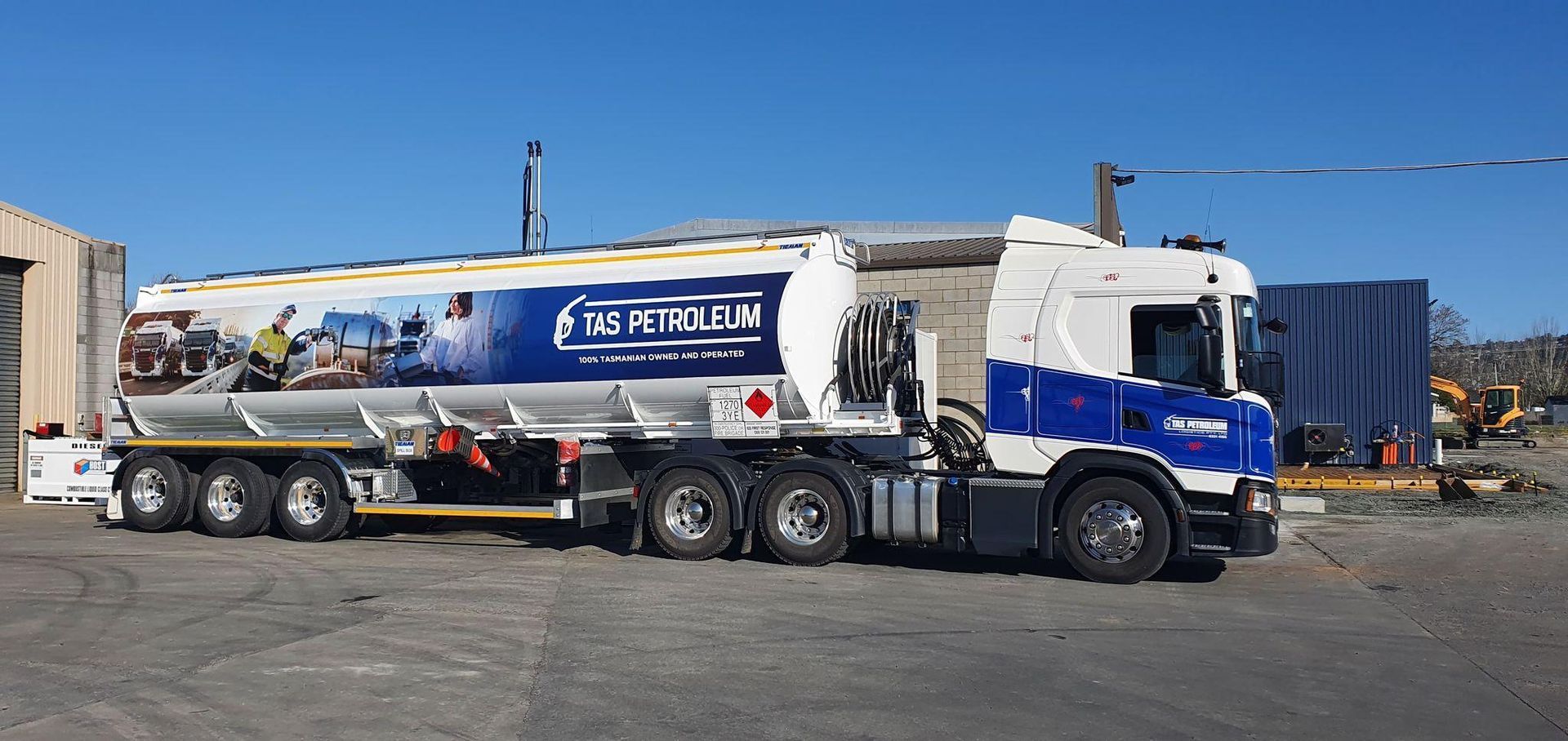 A blue and white tanker truck is parked in a parking lot.