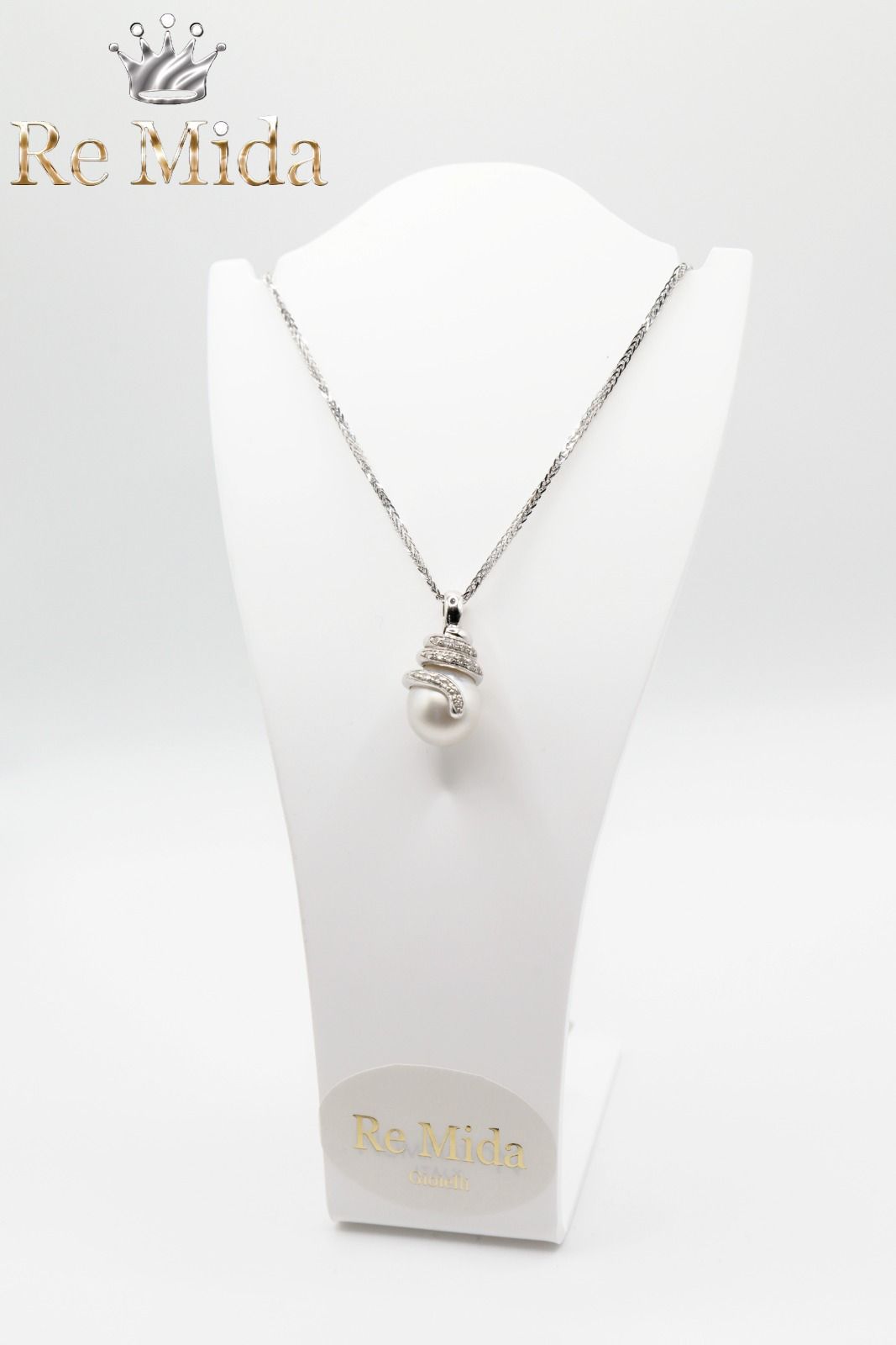Collana in argento con pendente di perla su un espositore bianco.