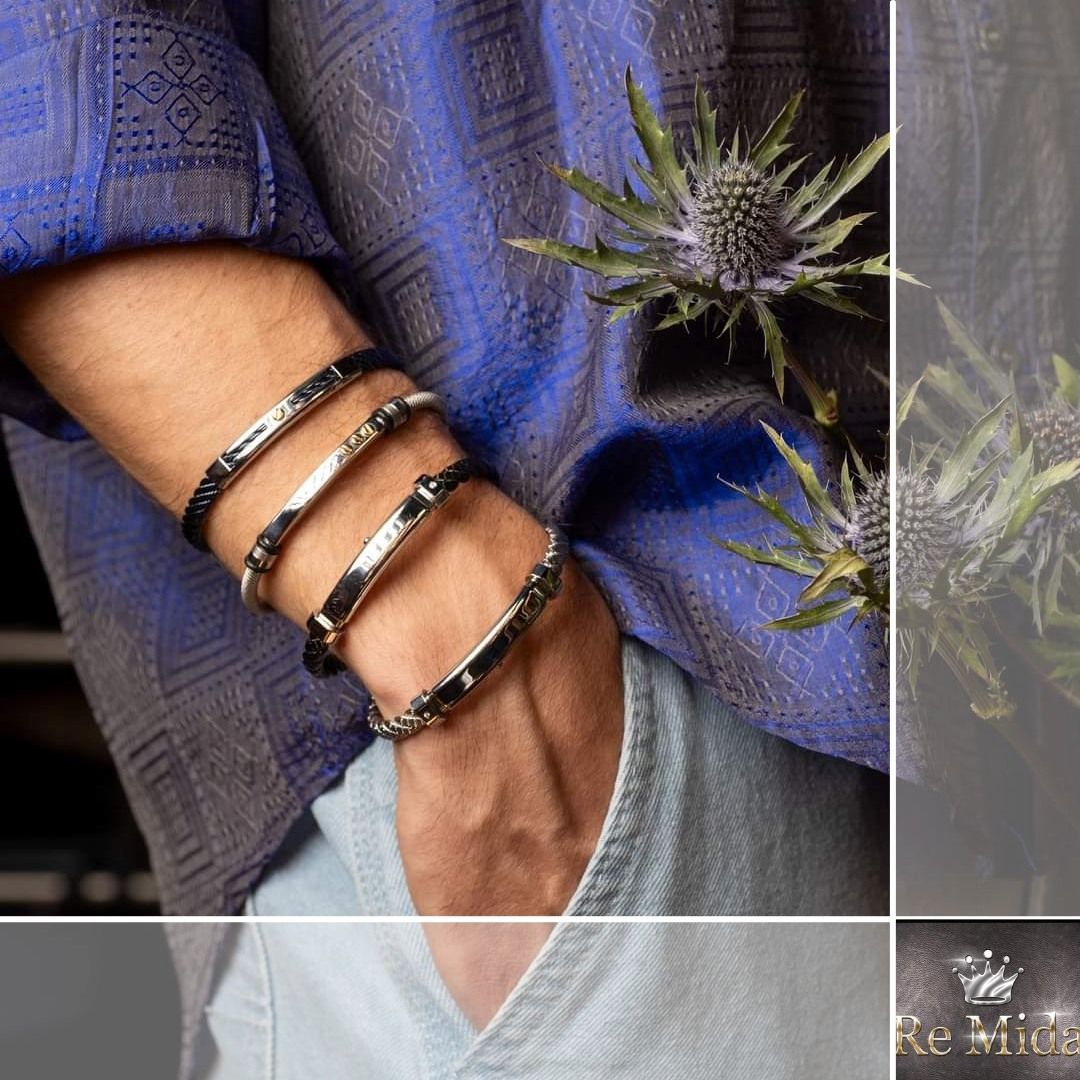 Braccialetti d'argento al polso, camicia blu, jeans blu e un cardo.