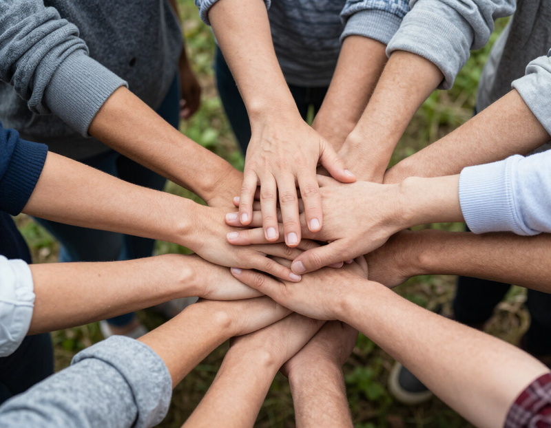 Hands stacked together in a huddle