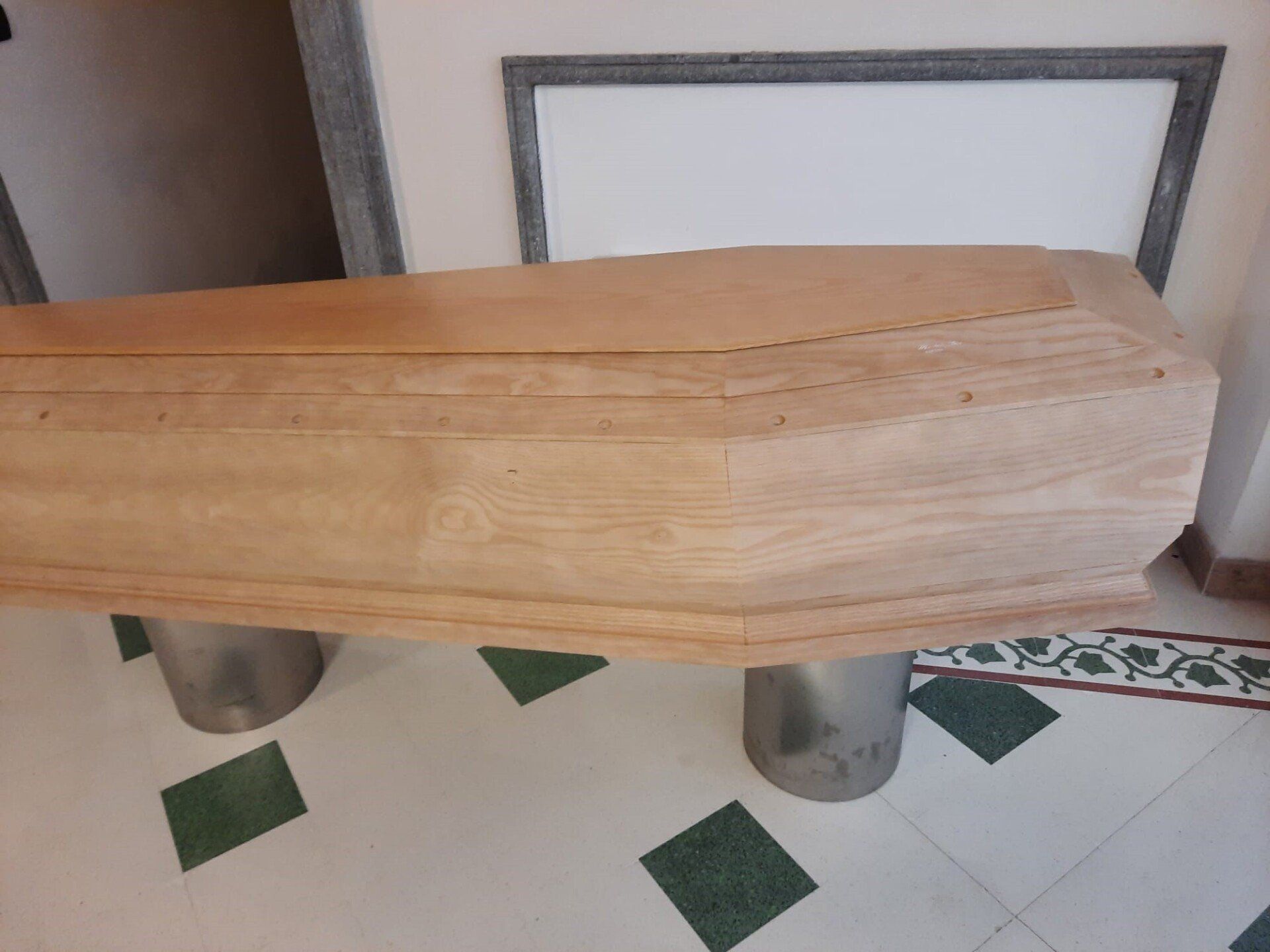 Bara di legno appoggiata su supporti metallici in una stanza piastrellata