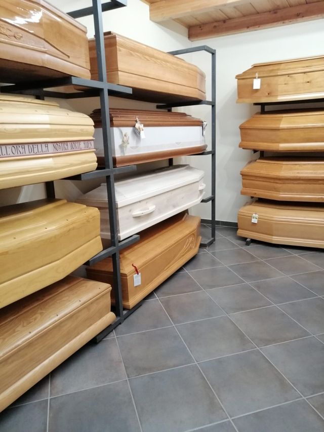 Bare di legno impilate su scaffali di metallo in un ripostiglio piastrellato.