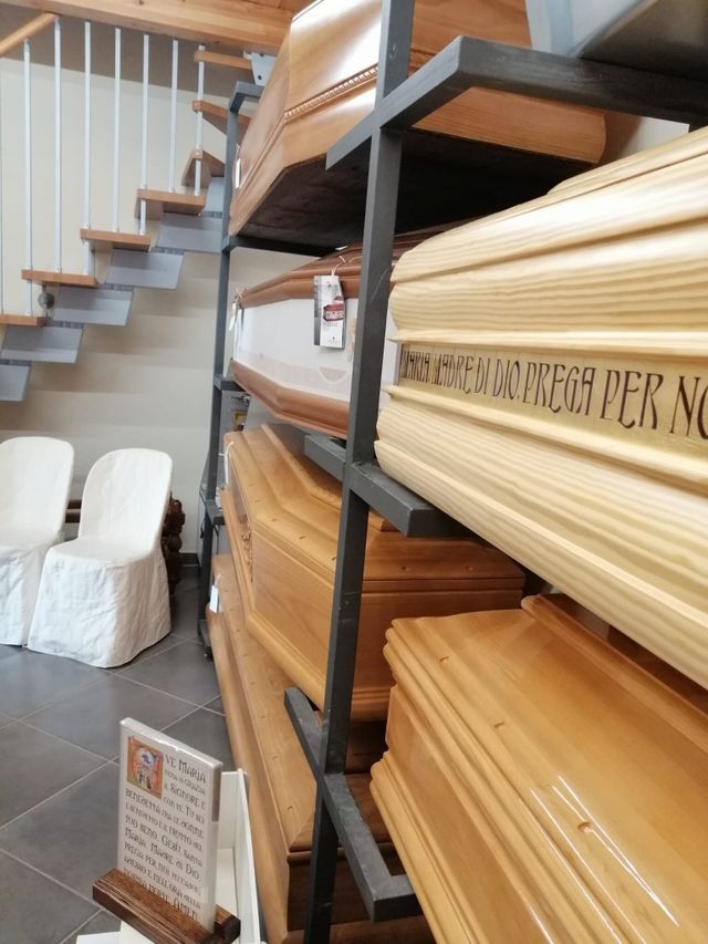 Scaffalature di modanature in legno lamellare in un negozio accanto a una scala e due sedie bianche