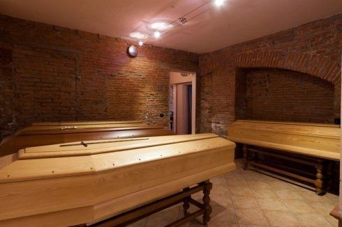 Sauna in mattoni con panche in legno e luci calde dal soffitto.