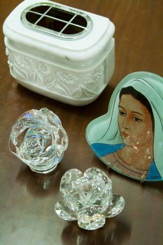 Tre flaconi di profumo in cristallo e un contenitore decorativo bianco con il ritratto di una donna