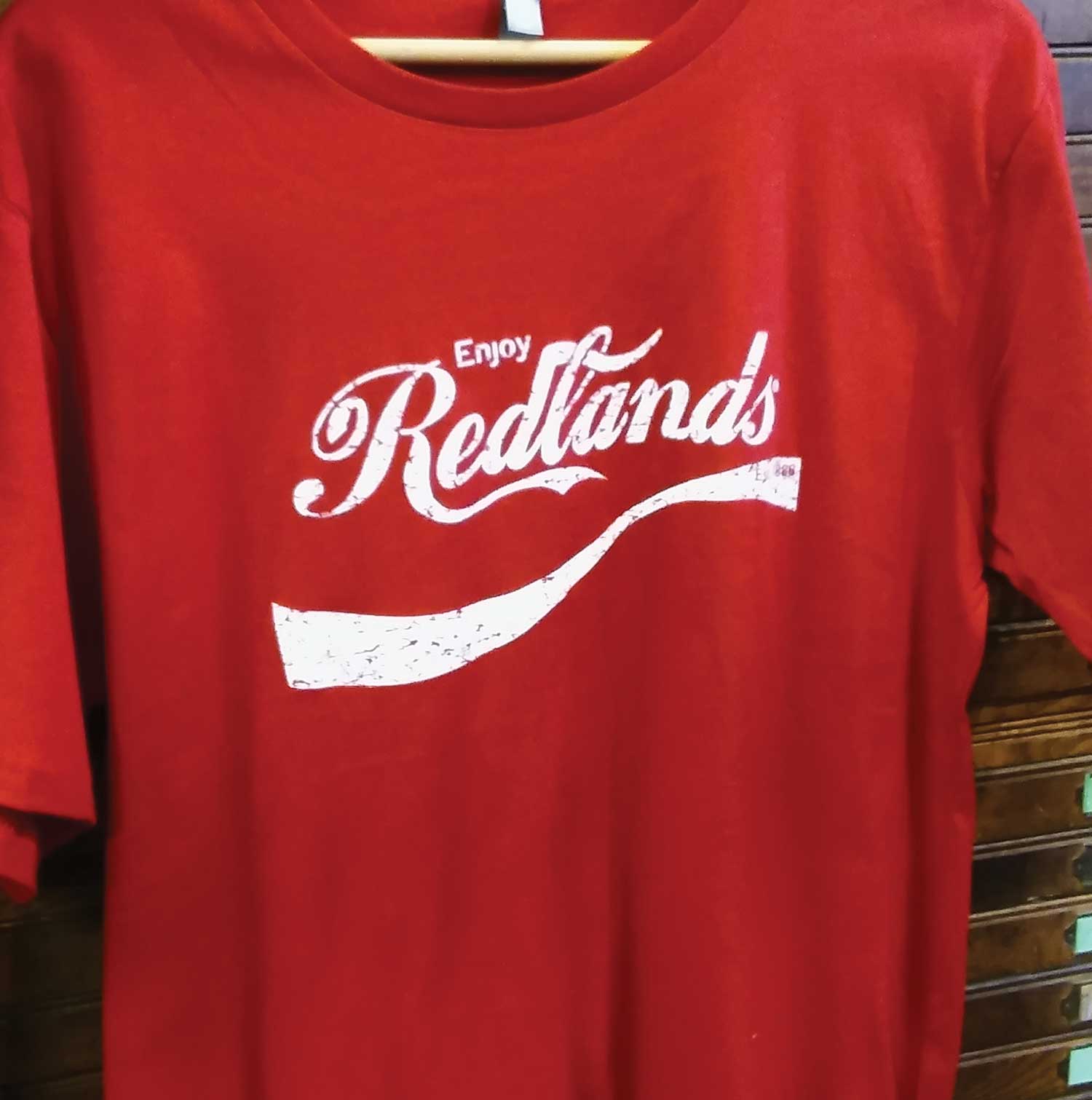A red t-shirt that says enjoy redlands on it