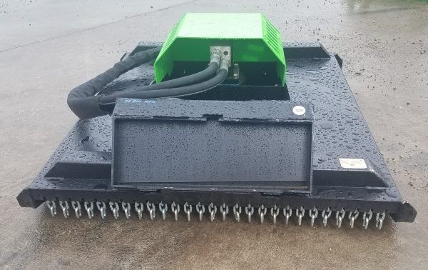 A green and black machine is sitting on the ground.