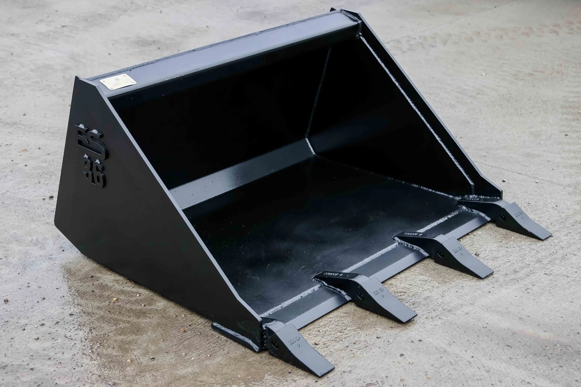 A black bucket is sitting on a concrete surface