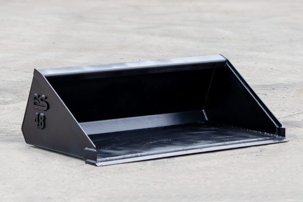 A black bucket is sitting on a concrete surface.