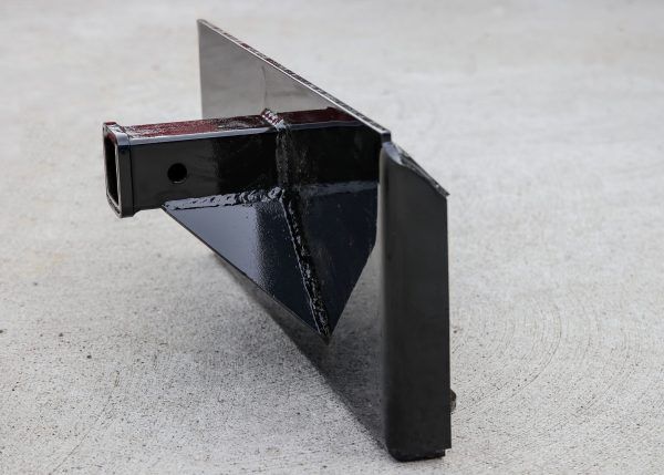 A black metal object is sitting on a concrete surface.