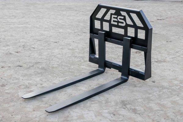A pair of forklift forks sitting on a concrete surface