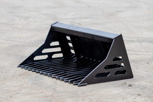 A black bucket with holes in it is sitting on the ground