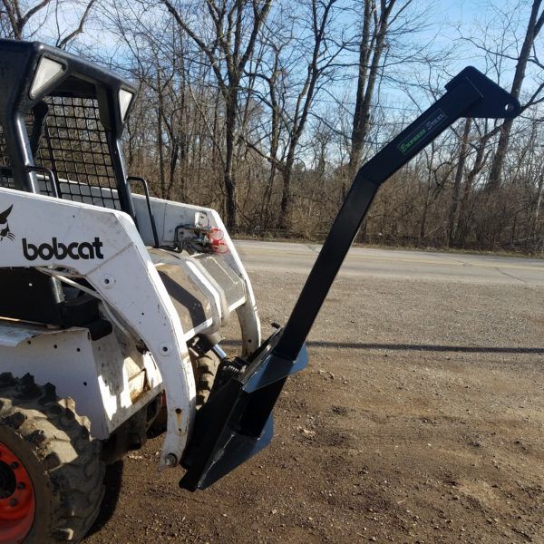 A bobcat is parked on the side of the road
