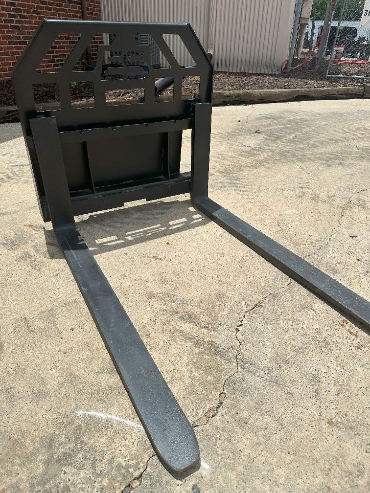A pair of forks sitting on top of a concrete surface.