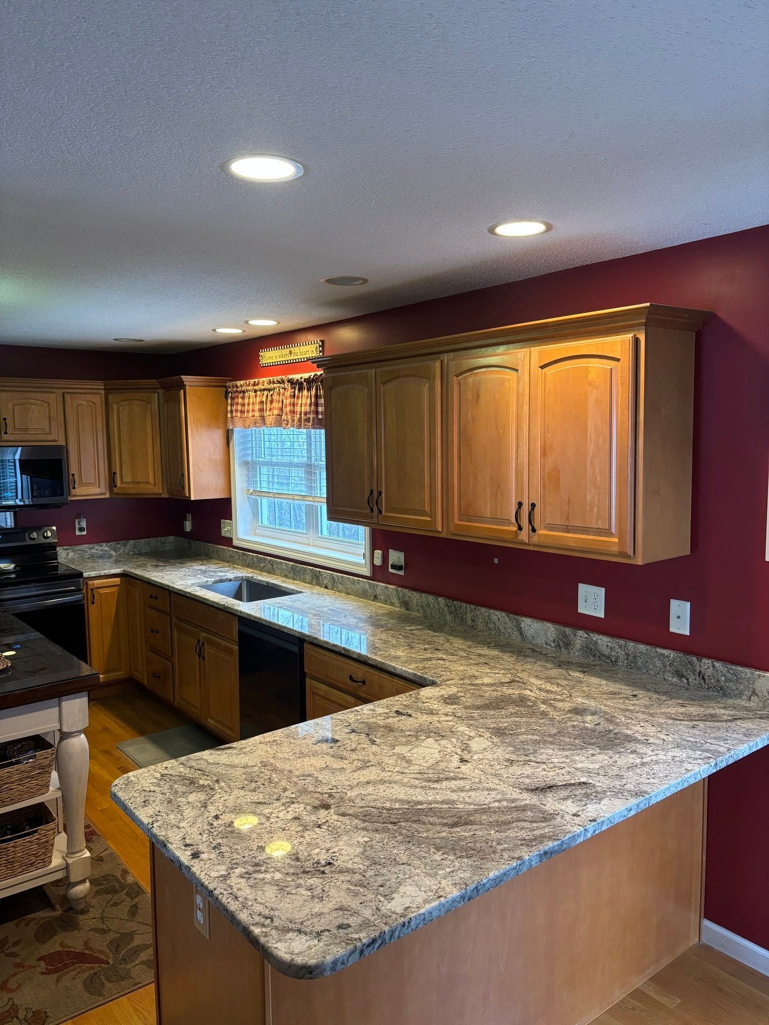 Modern kitchen with wood cabinets, granite countertops, and recessed ceiling lights
