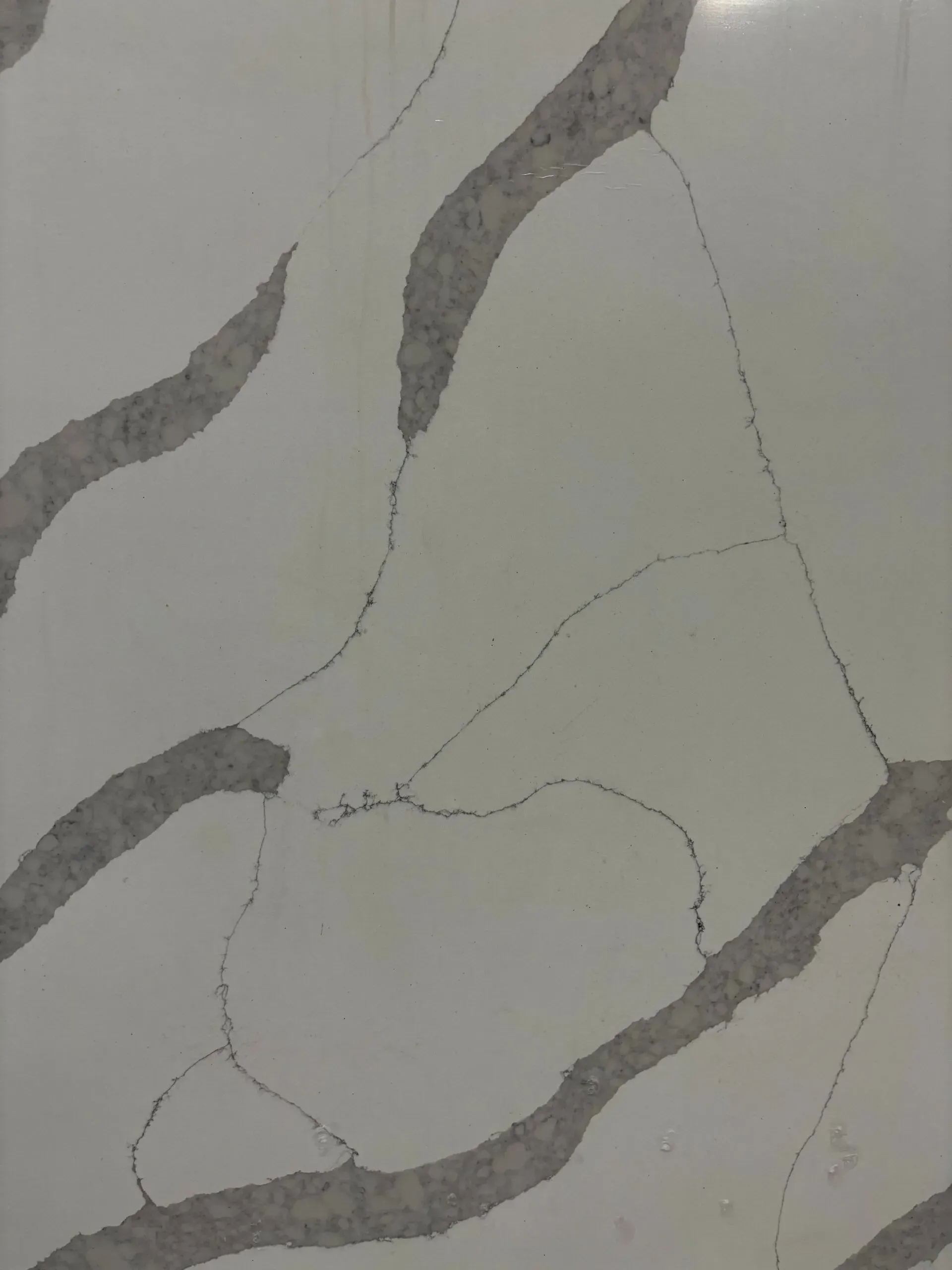 Gray marble-like surface with dark veining and cracks
