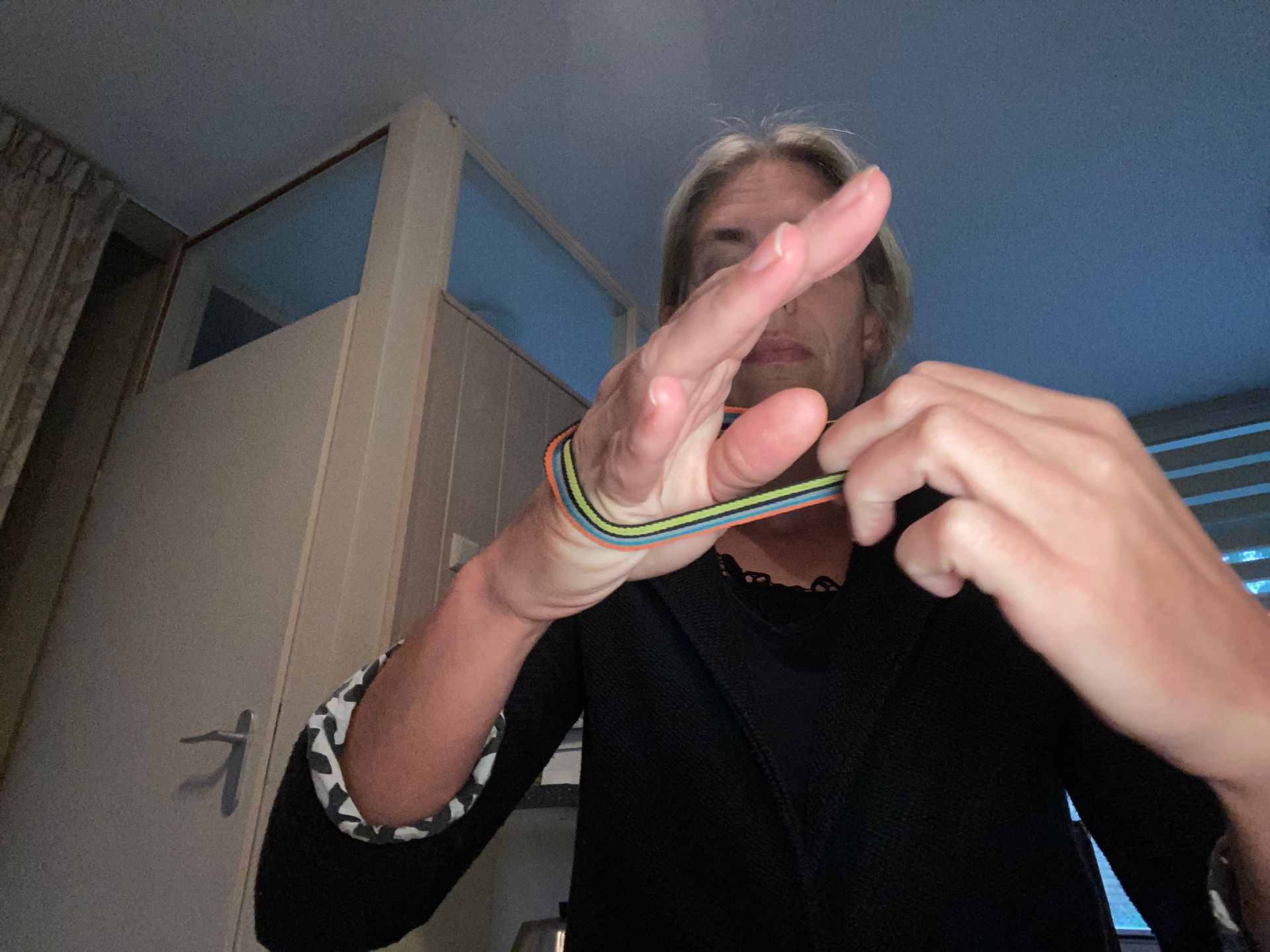 Iemand die een elastiekje tussen zijn vingers uitrekt.
