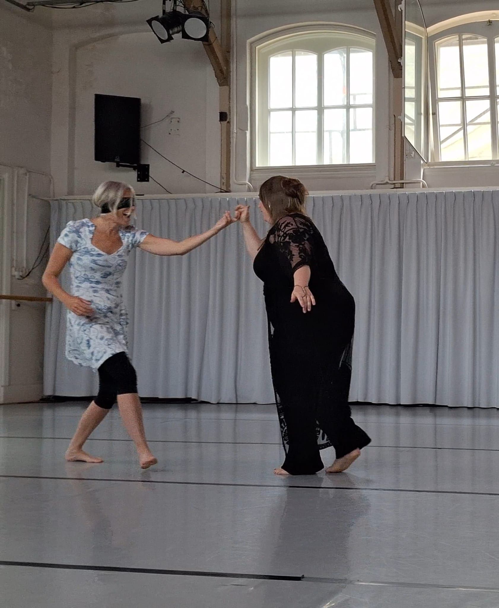 Twee vrouwen dansen op blote voeten in een studio.weergave van tantric dance