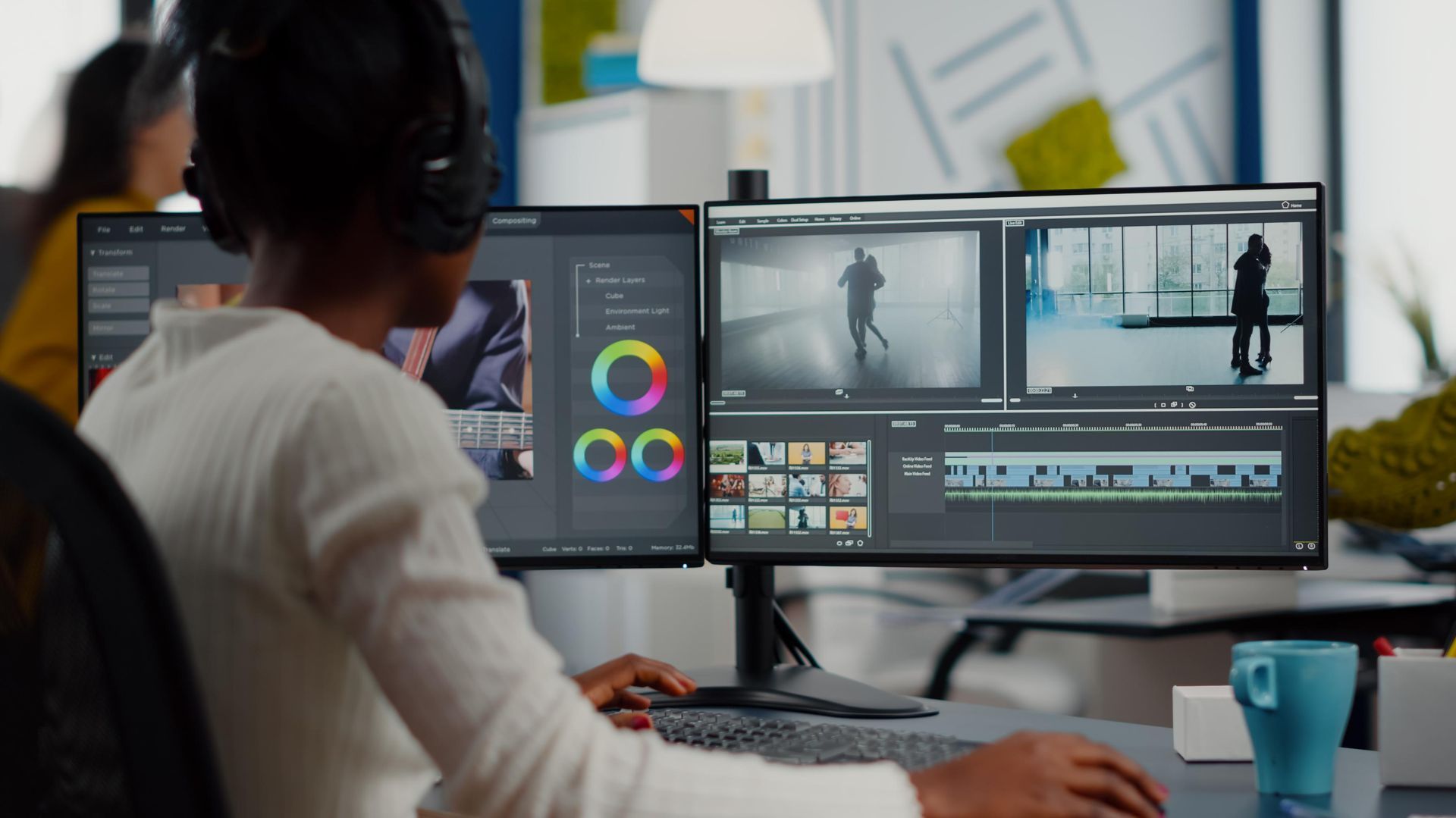 Person wearing headphones edits video on dual computer monitors, likely in an office.