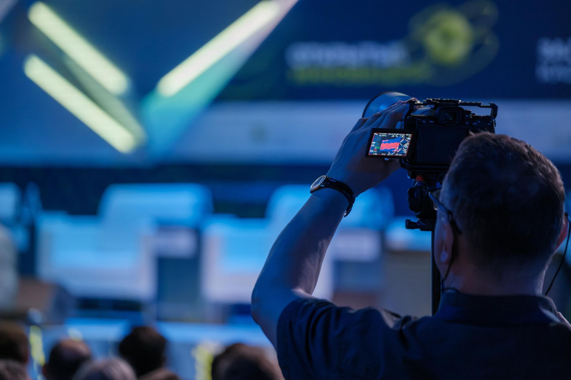 A person filming an event with a video camera. 