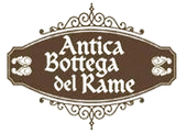 Un logo marrone di forma ovale con bordi decorativi a volute, contenente la scritta bianca 