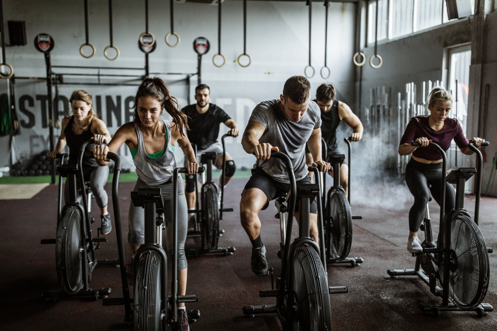a group of people are riding exercise bikes in a gym .