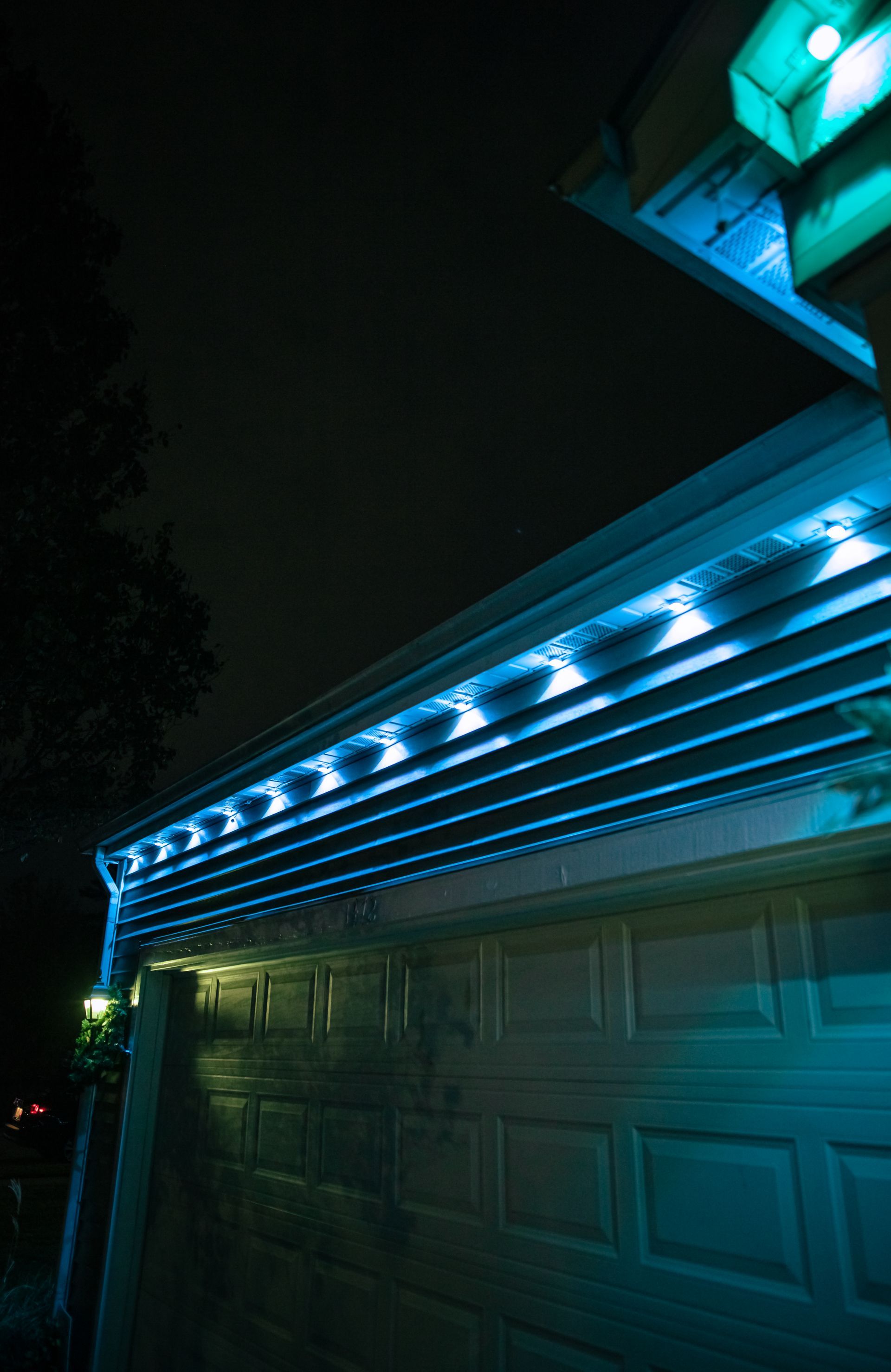 A garage door with blue lights on it at night.