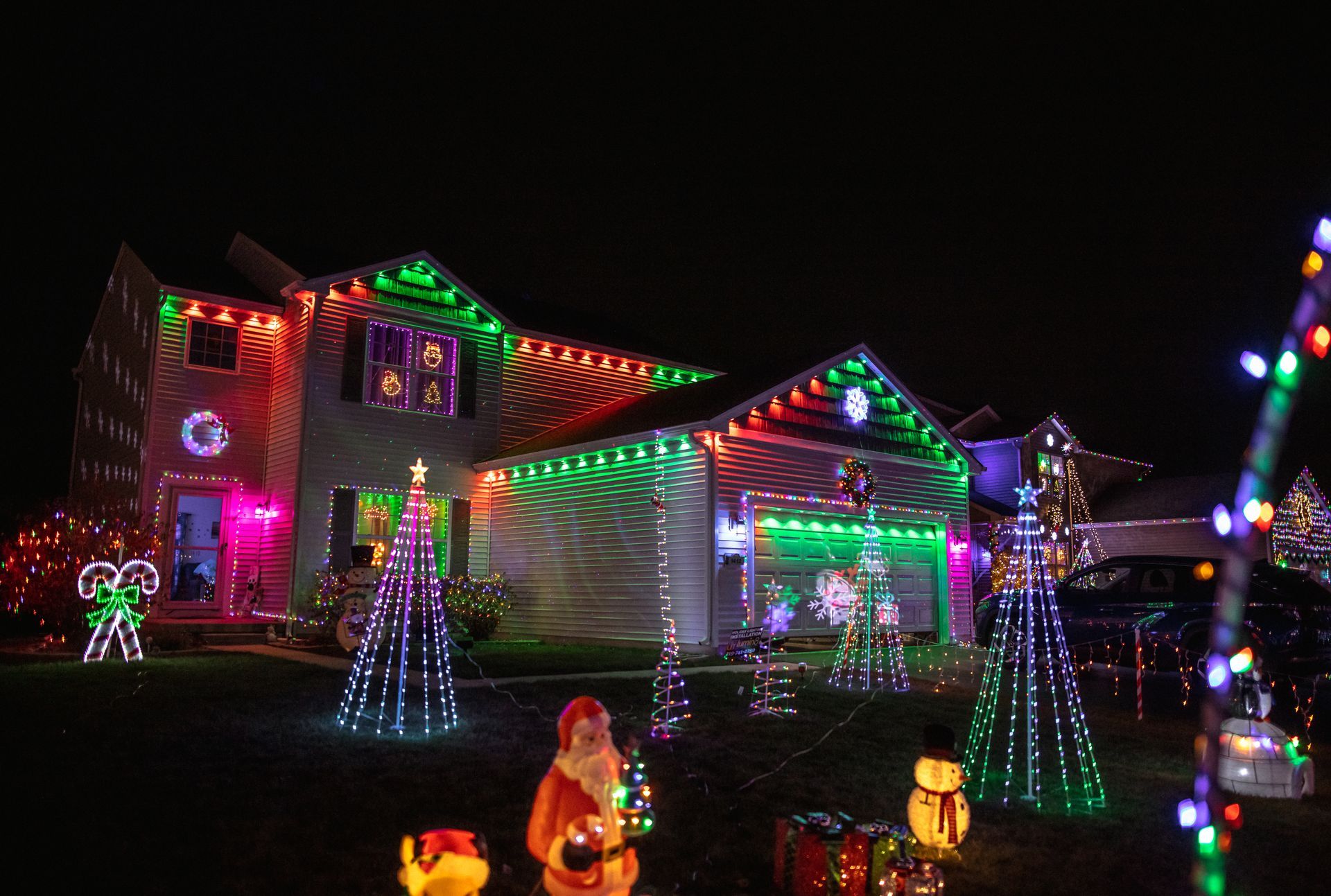 A house is decorated with lots of christmas lights at night.