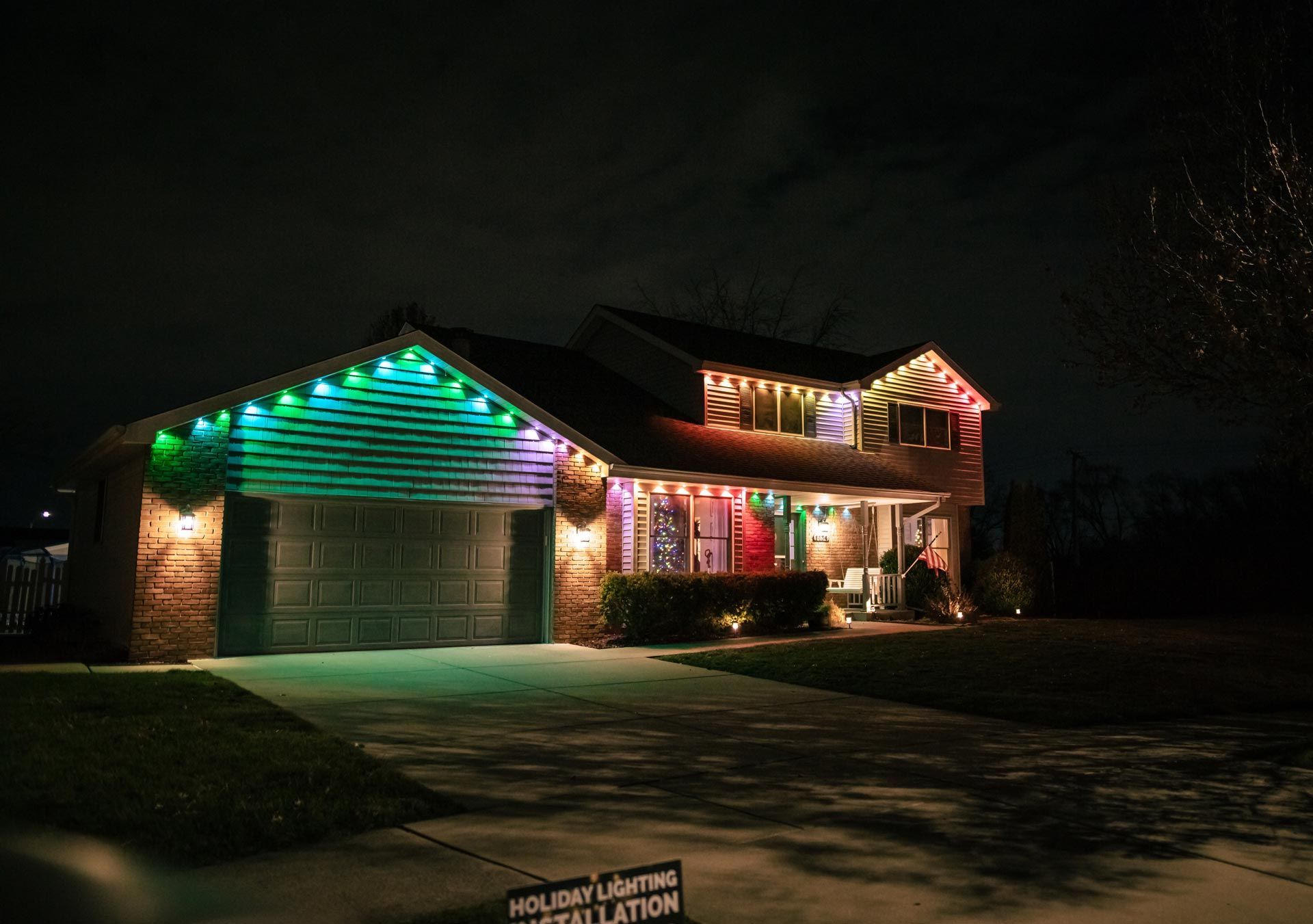 A house is decorated with christmas lights at night.