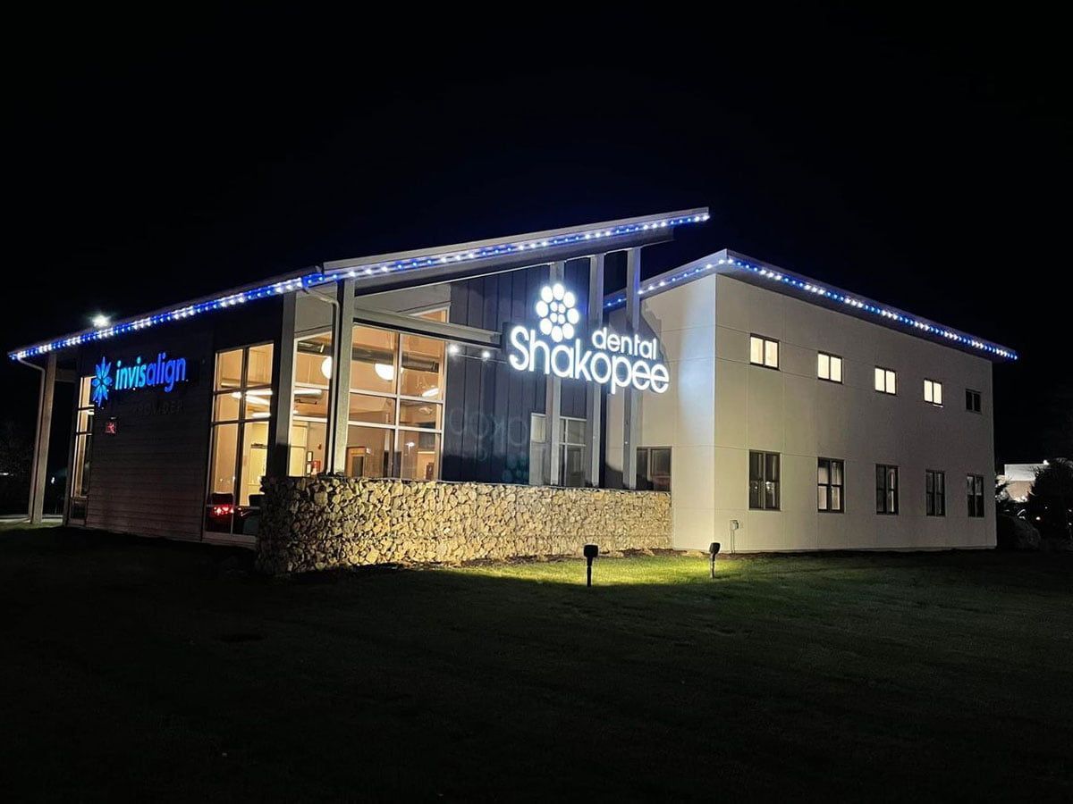 A large white building with a sign that says ' shokopee ' on it is lit up at night.