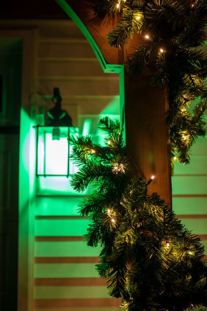 A staircase with a christmas tree and green lights on it.