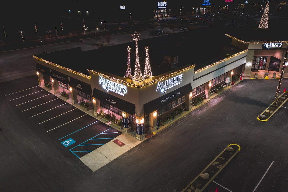 An aerial view of a building with christmas lights on it at night.