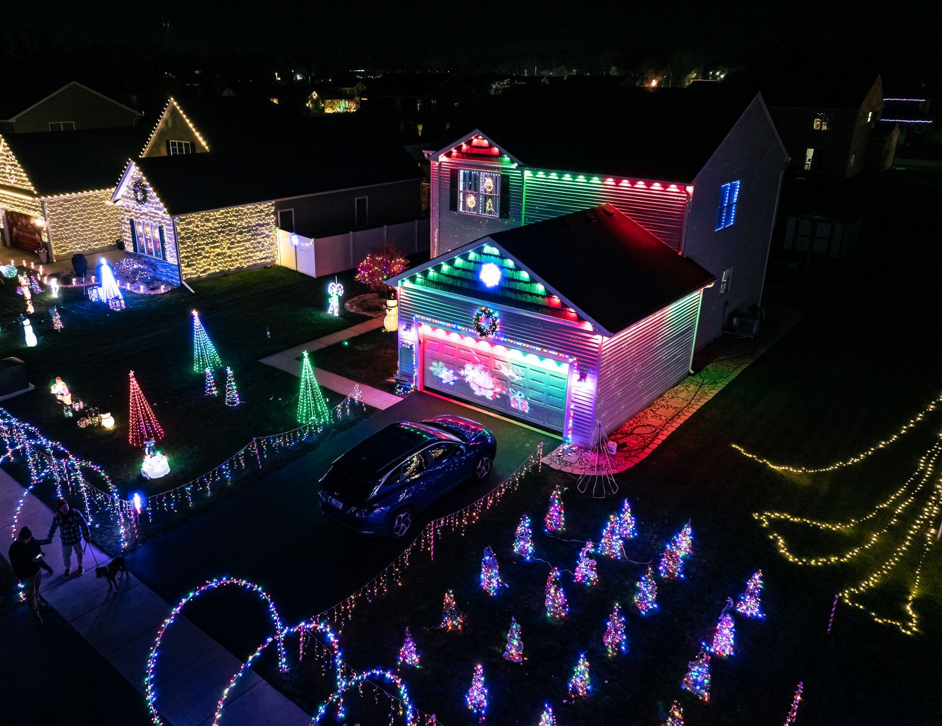 An aerial view of a house decorated with christmas lights at night.