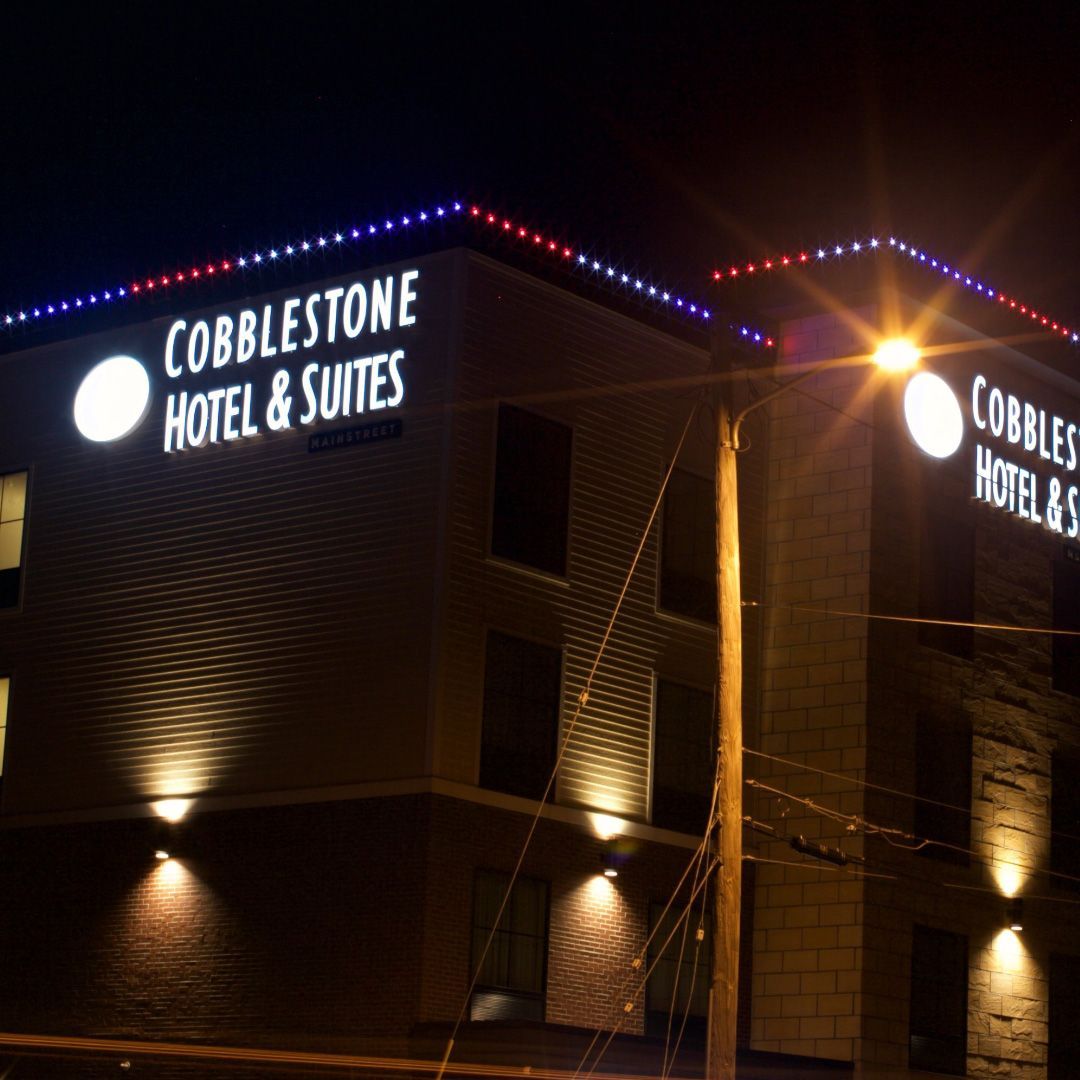 The cobblestone hotel and suites is lit up at night