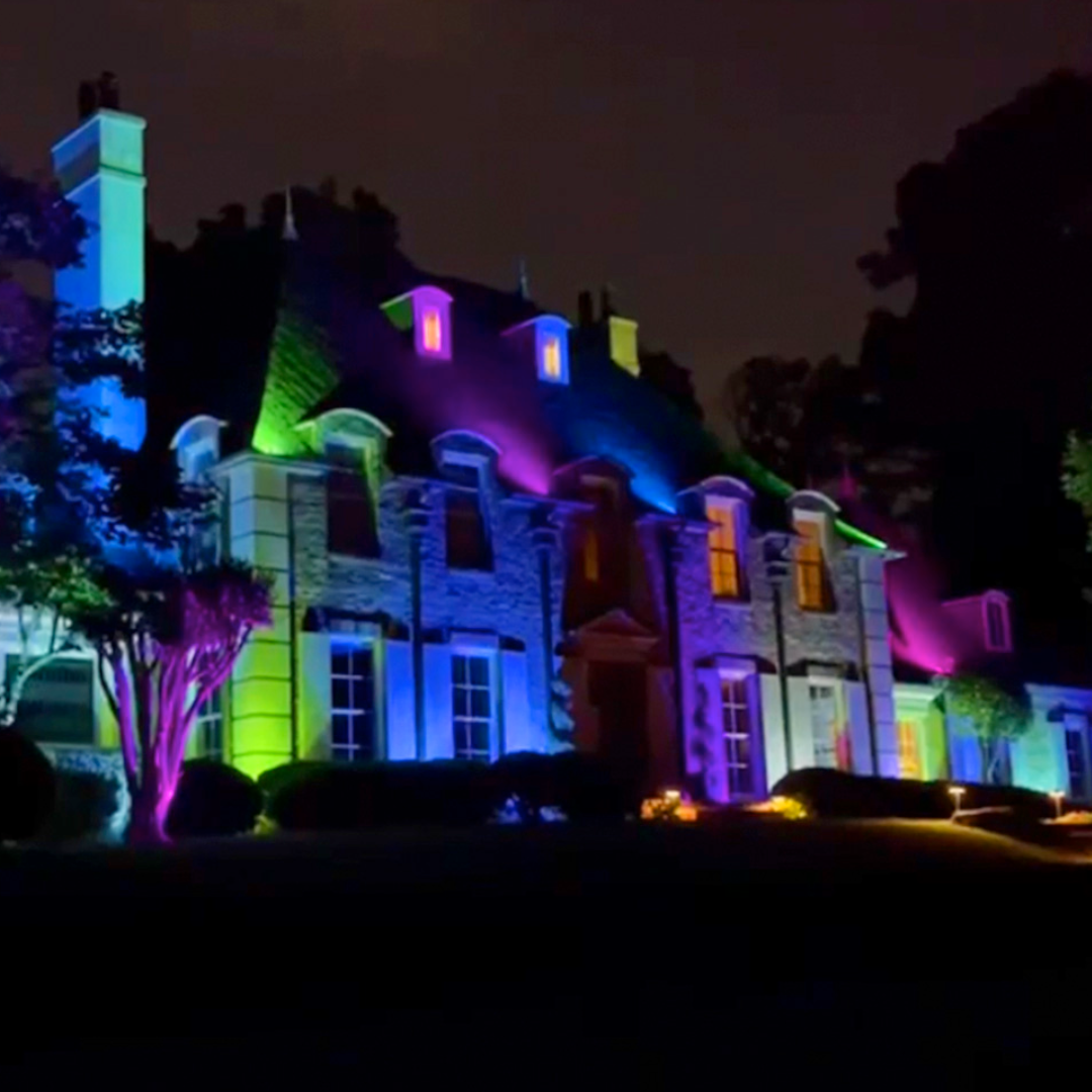 A house is lit up with a rainbow of colors at night