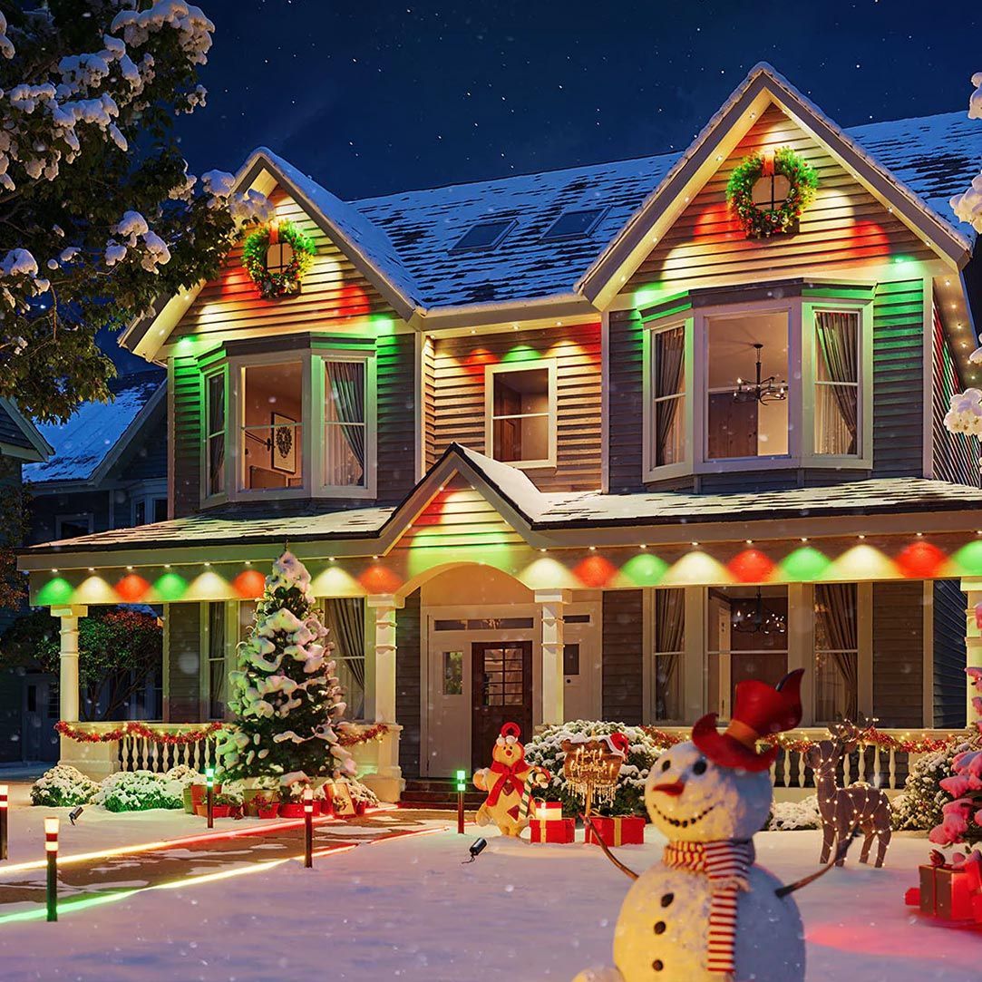 An aerial view of a street decorated with christmas lights at night.
