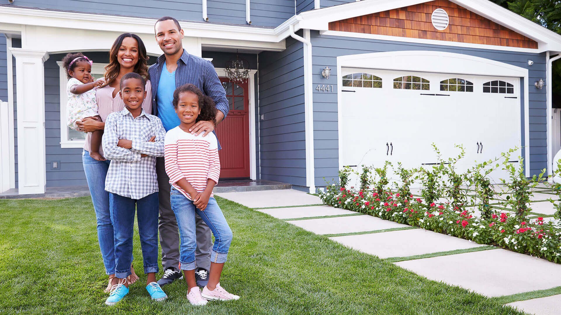 Photo of family standing in front of new home