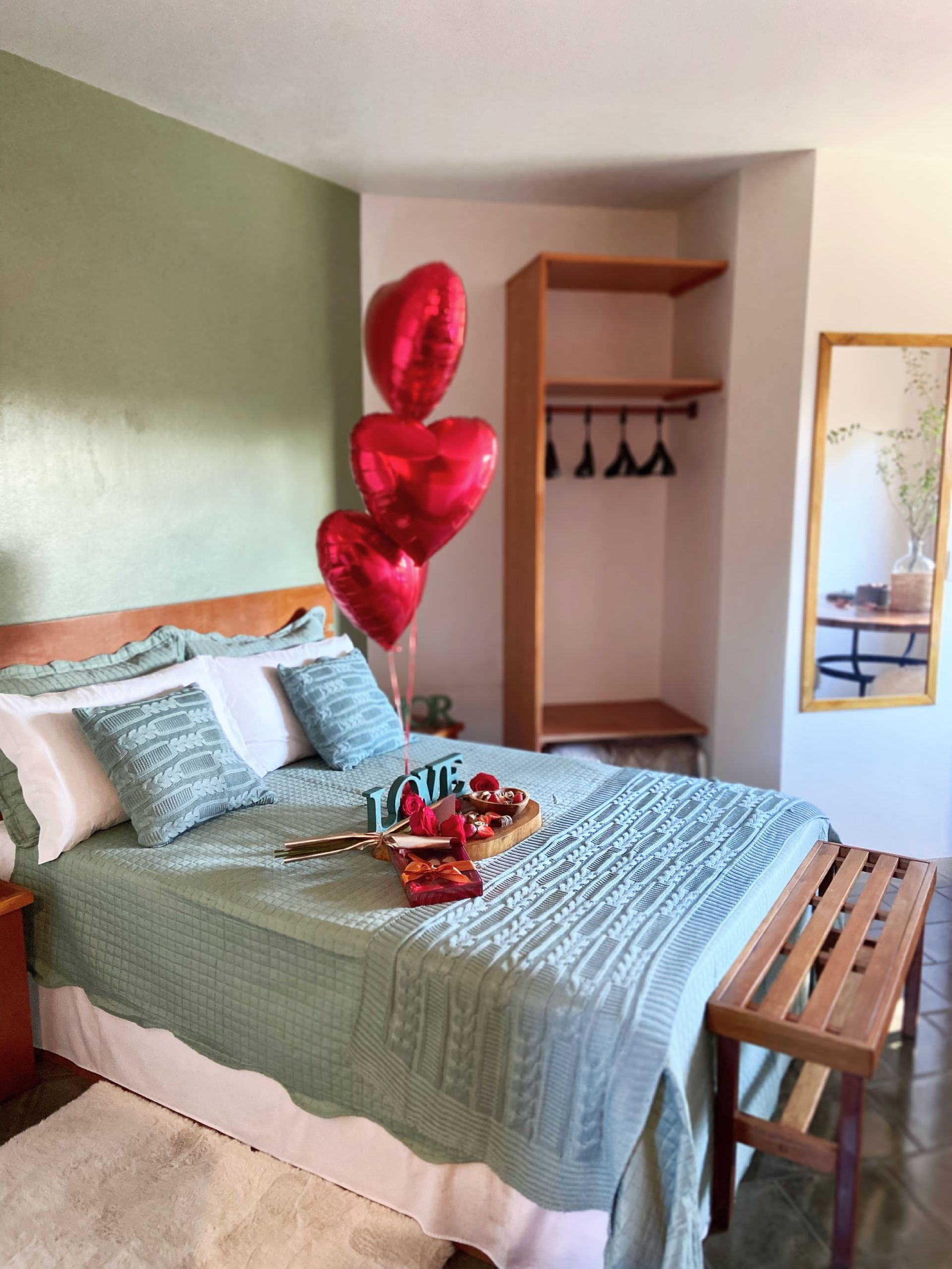 Um quarto com uma cama e balões que dizem amor