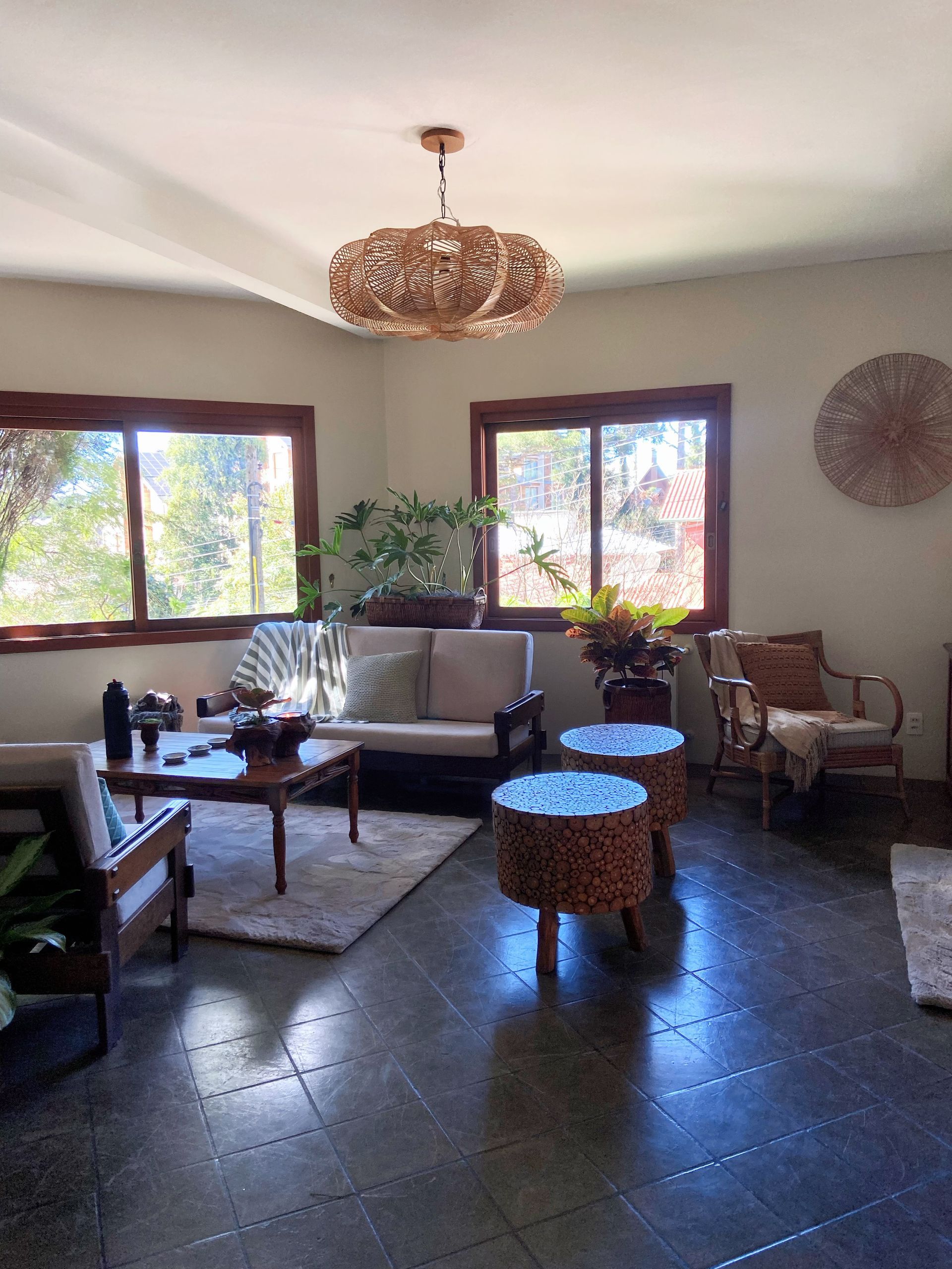 Uma sala de estar com um sofá, cadeiras, mesas e um lustre.