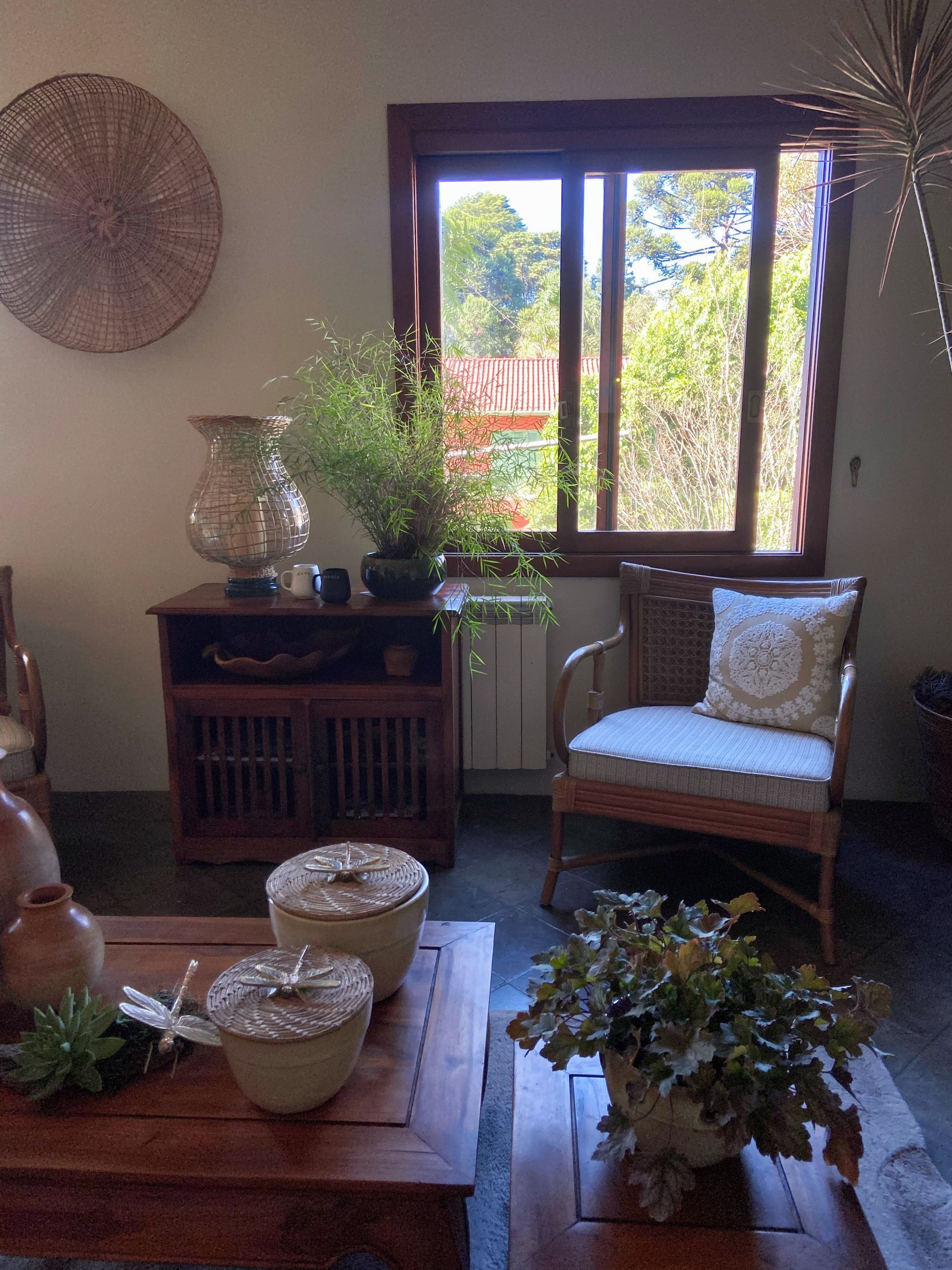 Uma sala de estar com uma cadeira, uma mesa e uma janela