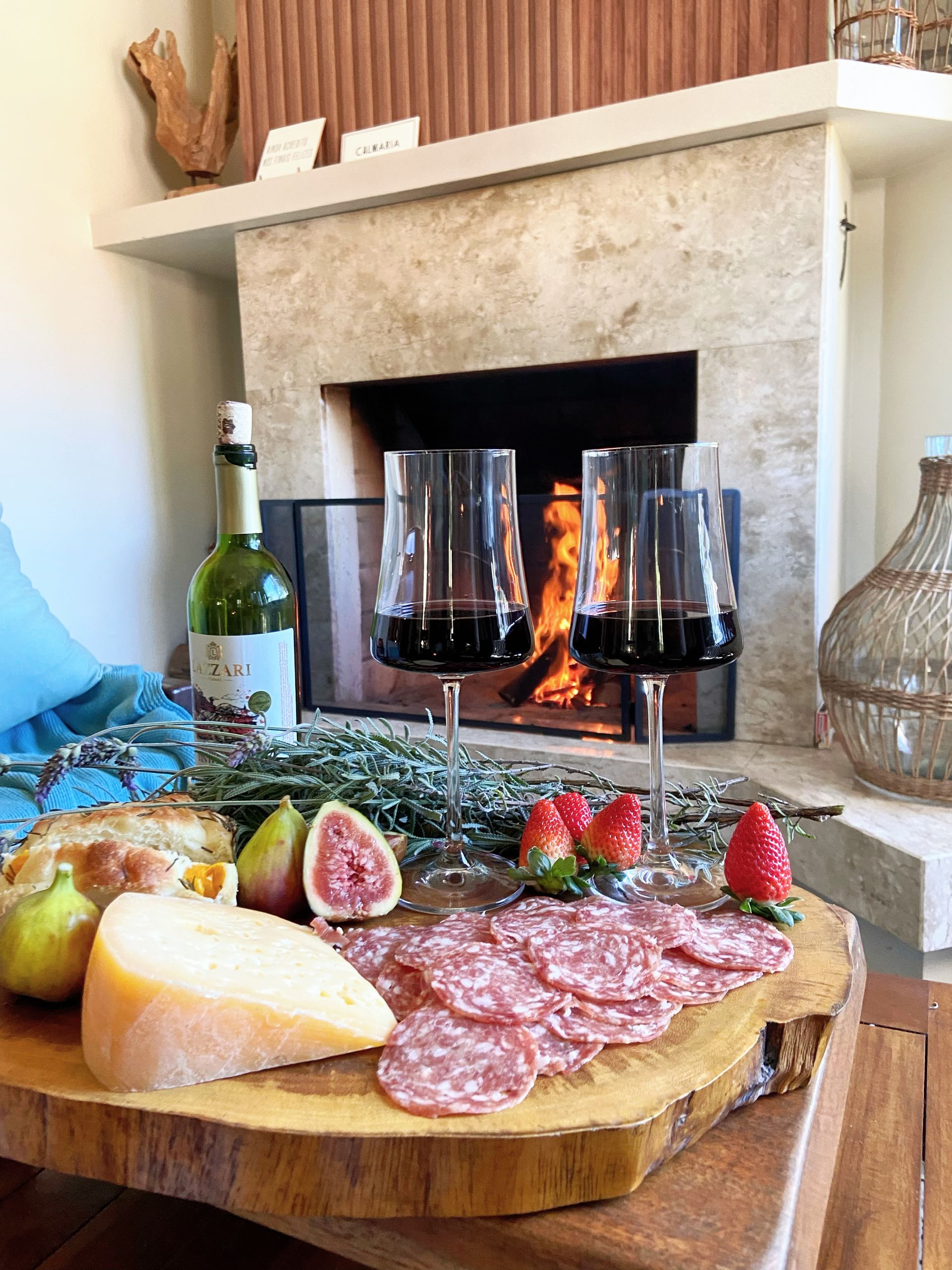Há uma garrafa de vinho e duas taças de vinho na mesa.