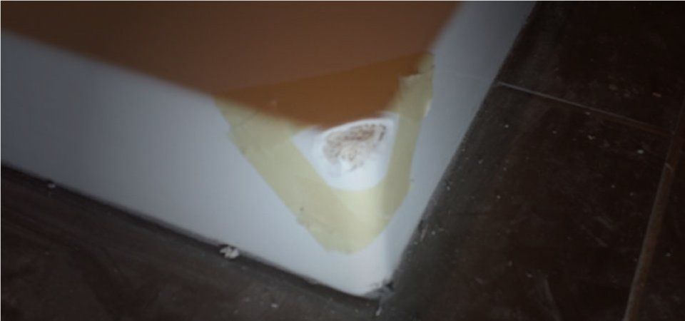 Gros plan sur un coin blanc ébréché et jauni sur un sol foncé