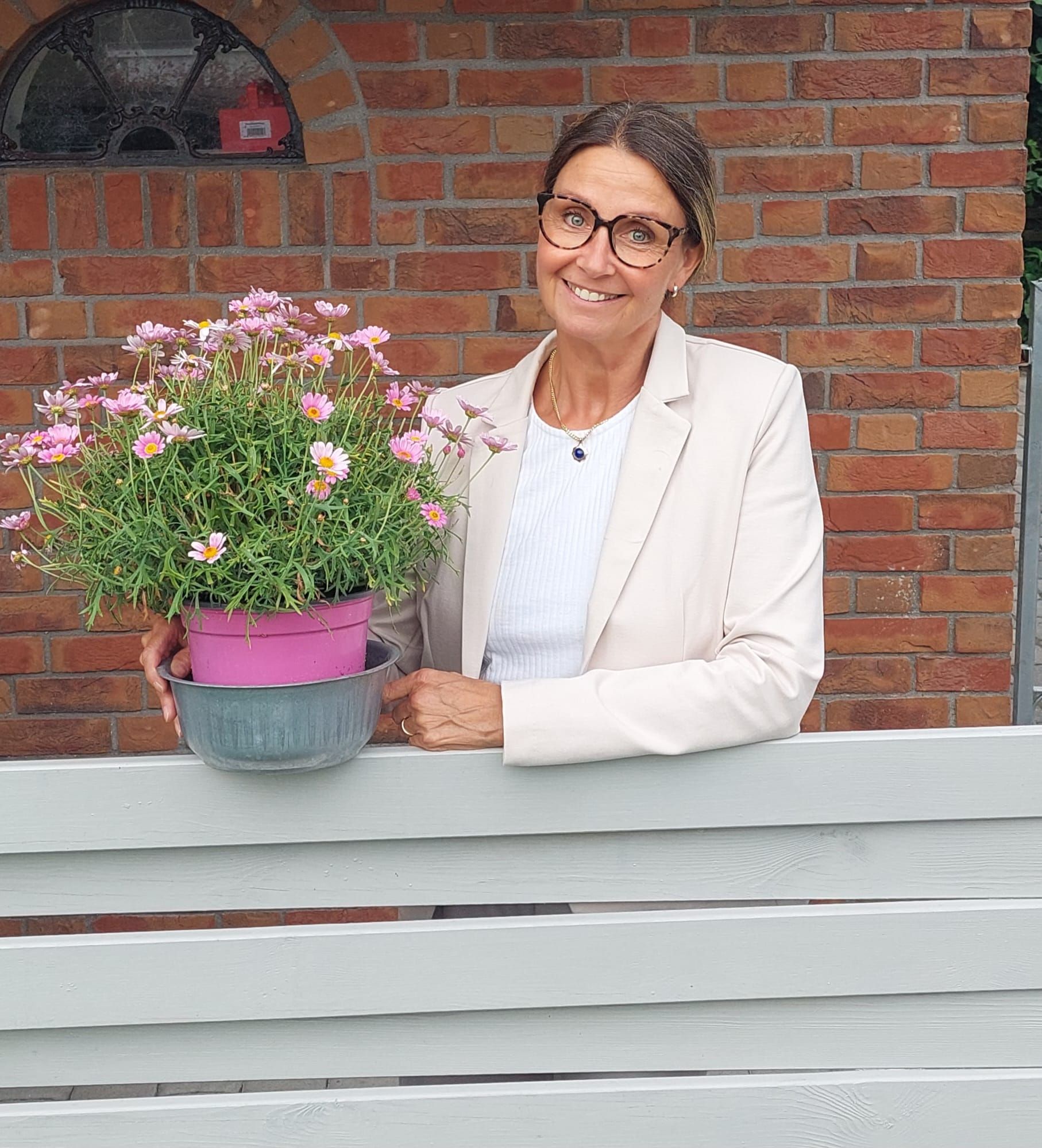 Auf einem Schwarzweißfoto lächelt eine Frau mit Brille.