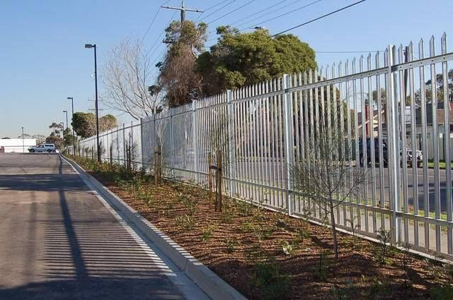 A metal fence along the side of a road