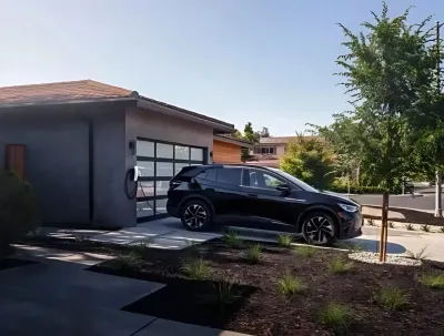 OE Services LLC - A black suv is parked in front of a house with a charging station.