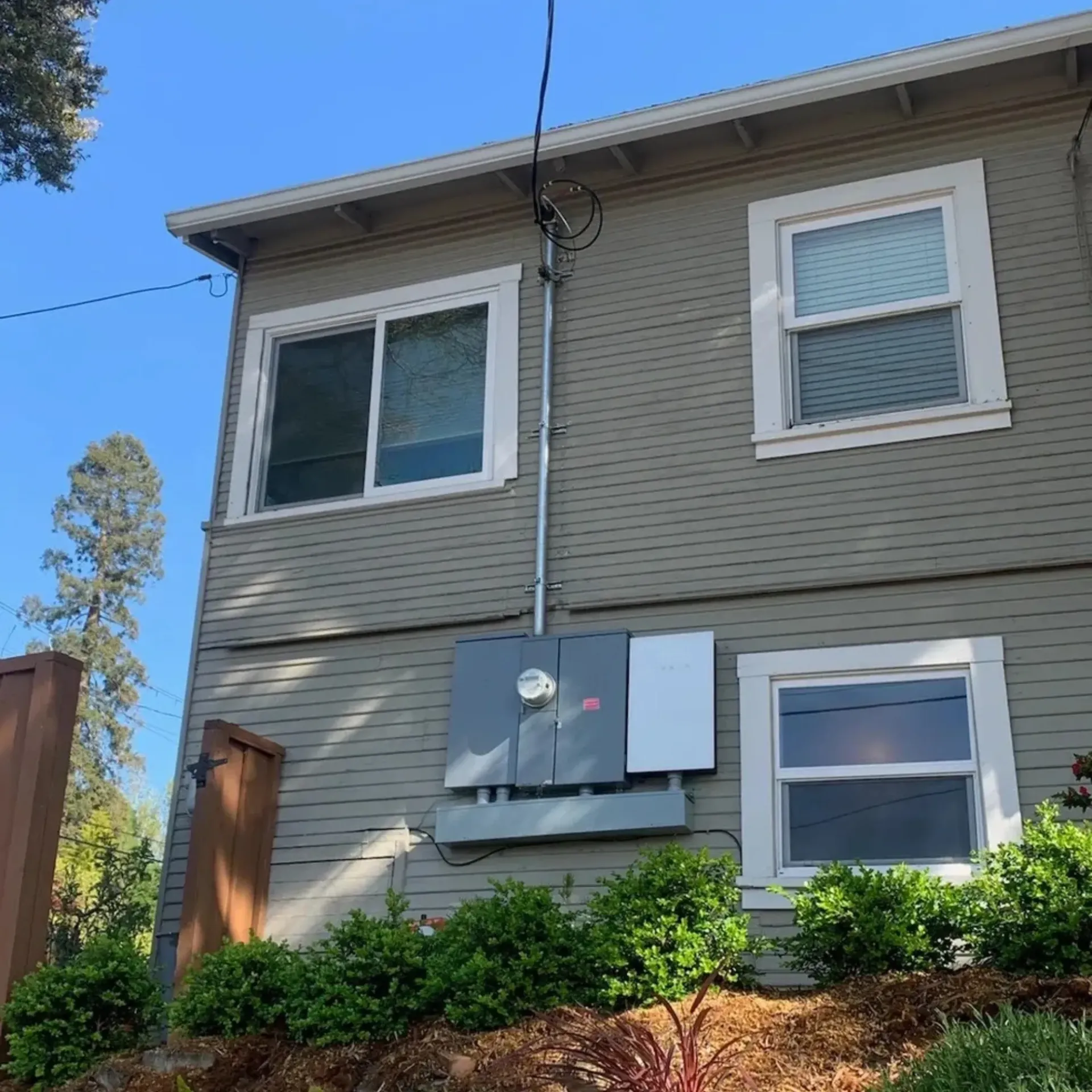 OE Services LLC - A house with a lot of windows and bushes on the side